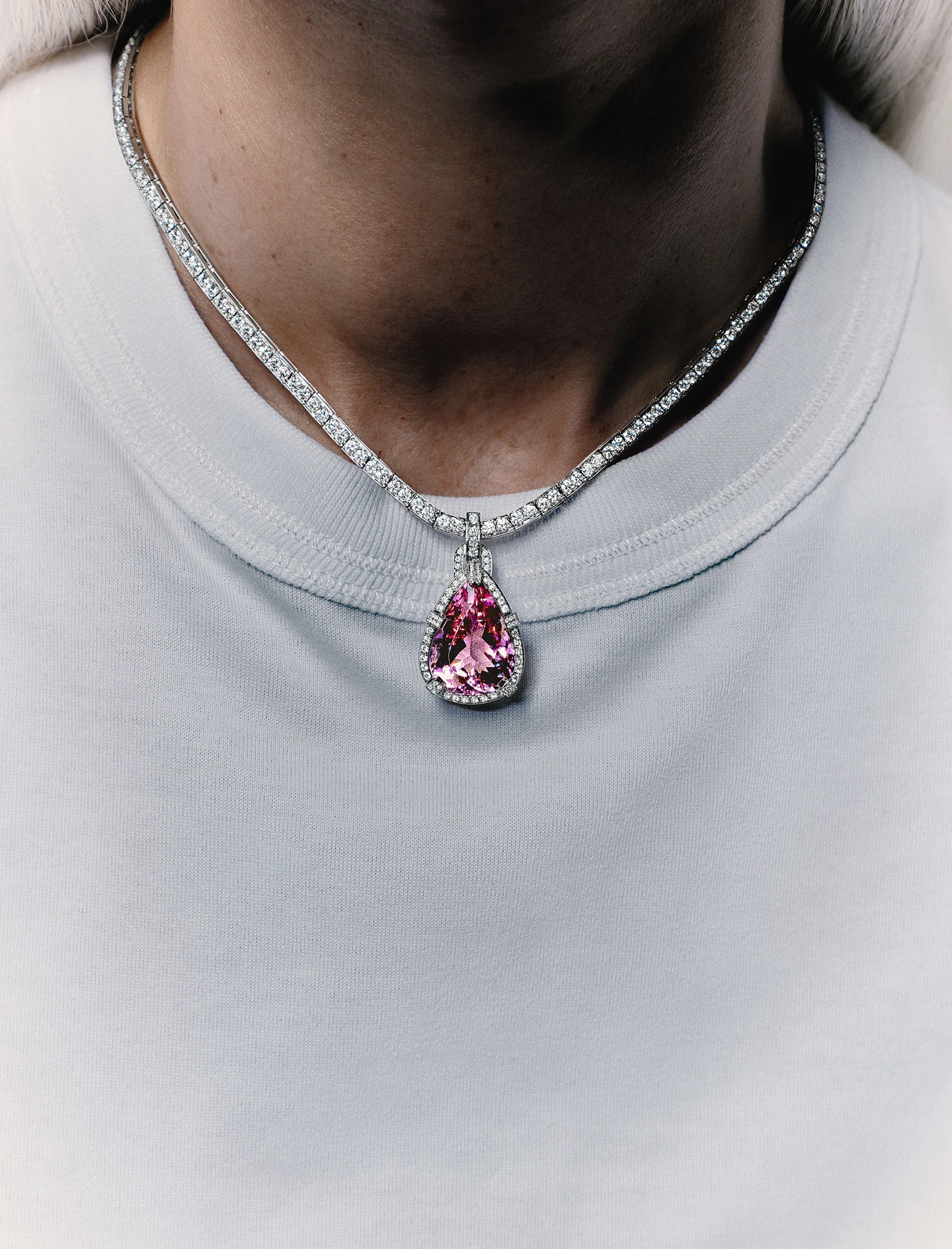 Pink Tiffany & Co. pendant against a white T-shirt
