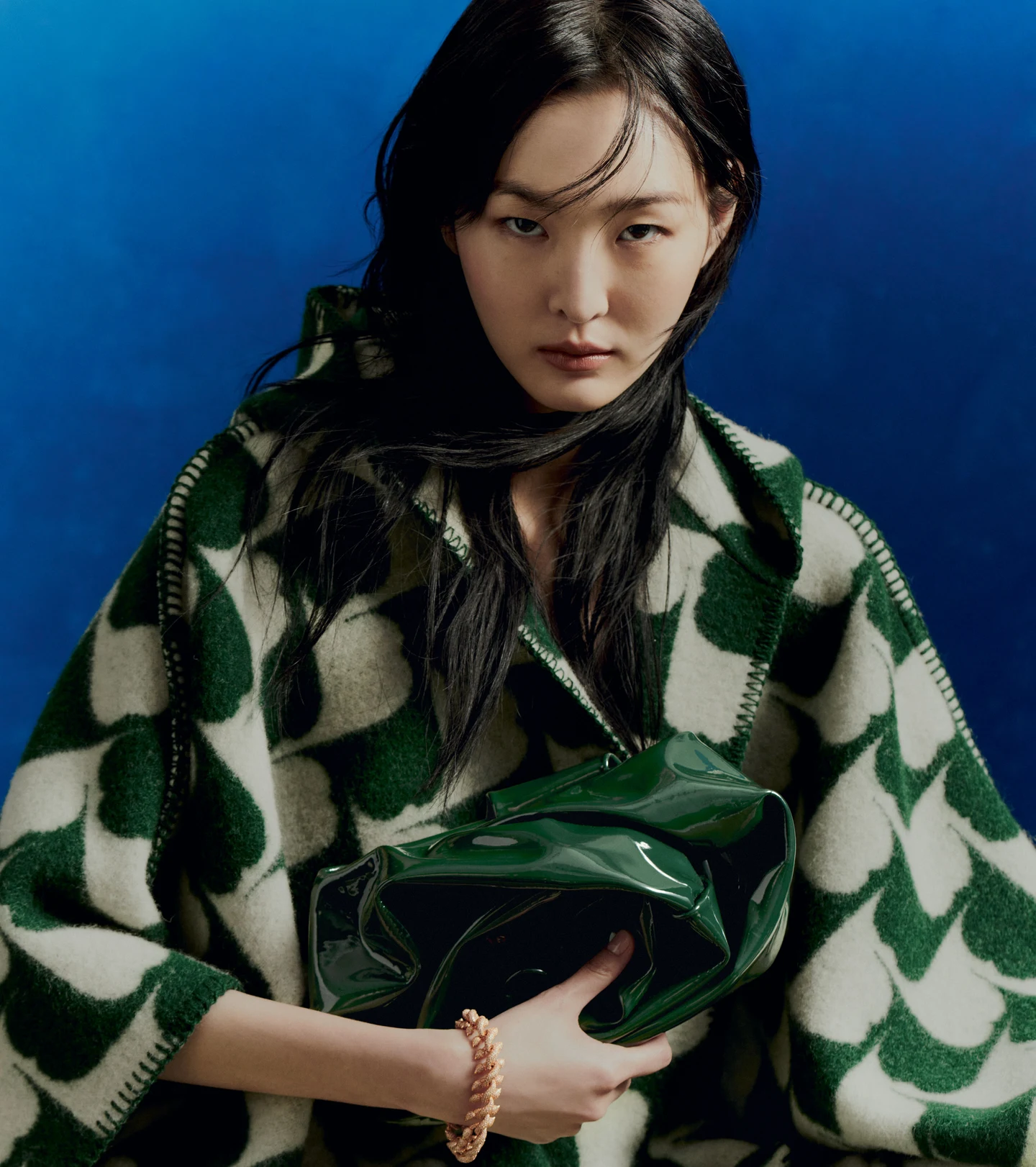 A green patterned Burberry coat against a blue background