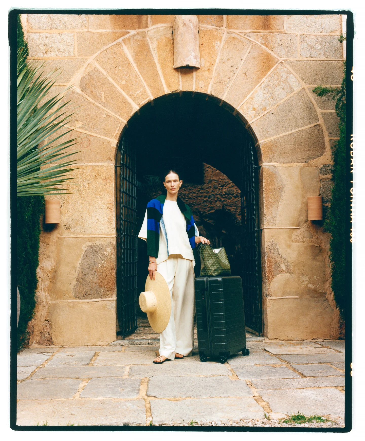 A light summer outfit framed by a stone archway