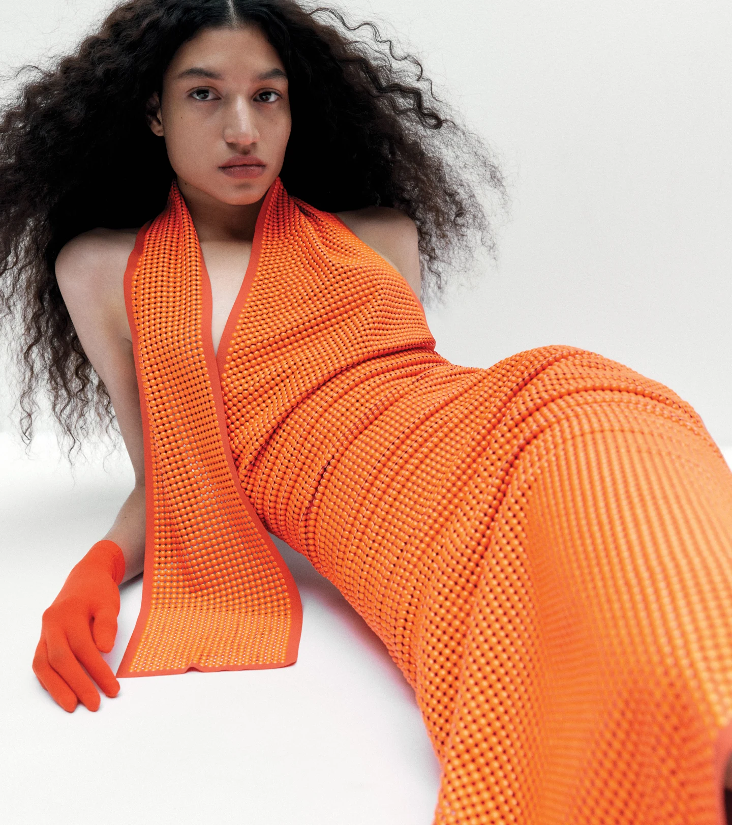 An orange ribbed outfit against a pale background