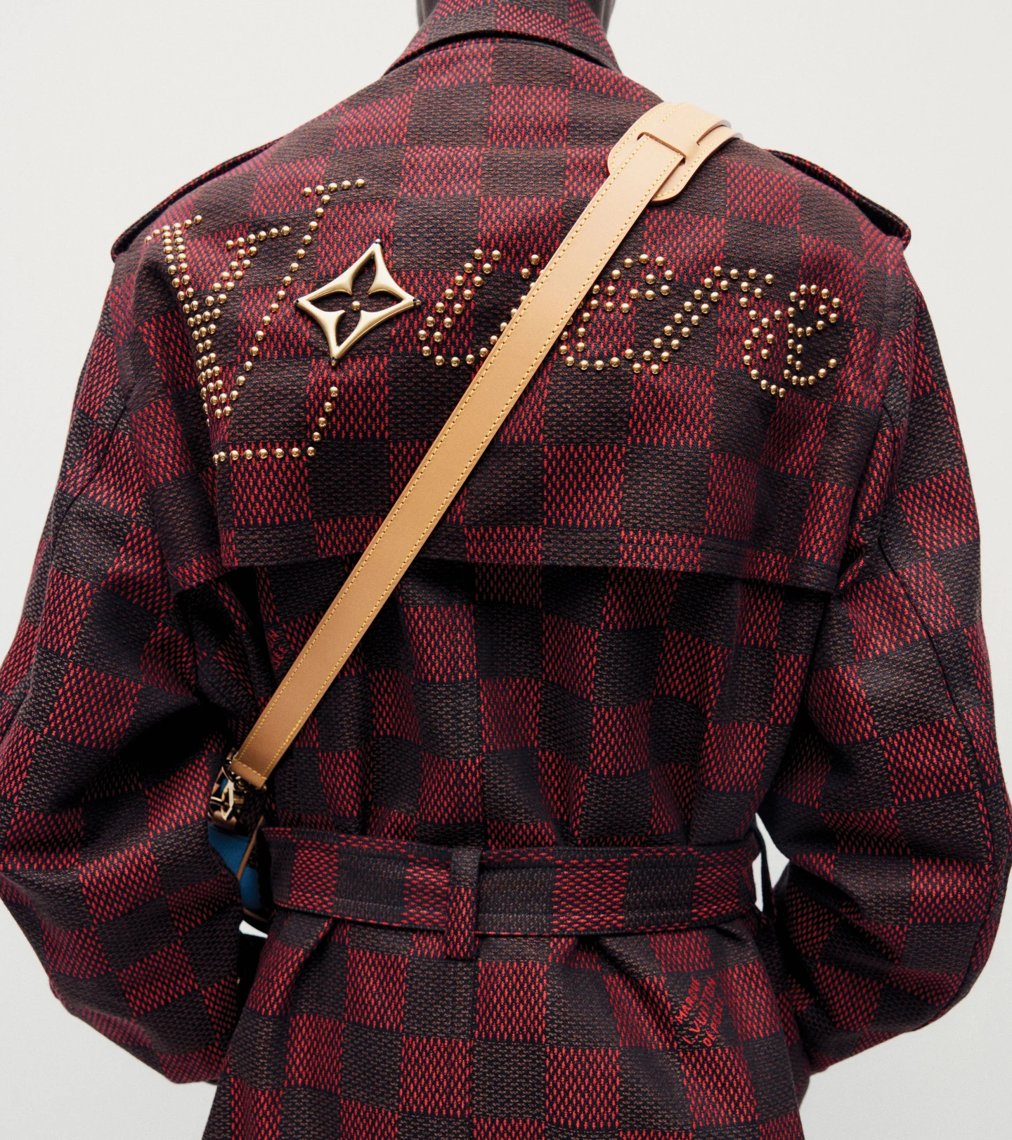 A red checked jacket with a monogrammed crossbody bag
