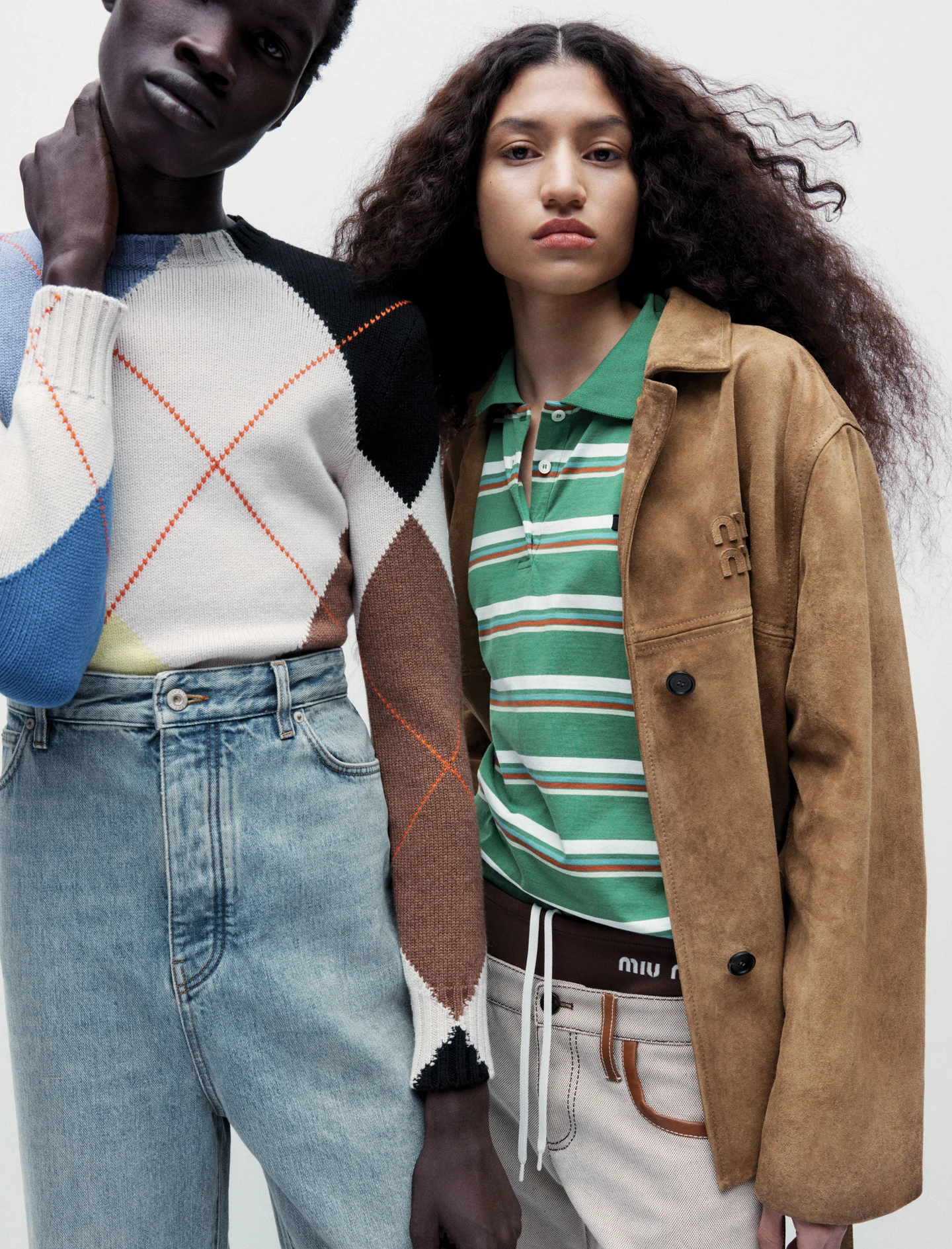 Two models in denim, a striped polo shirt and a brown jacket