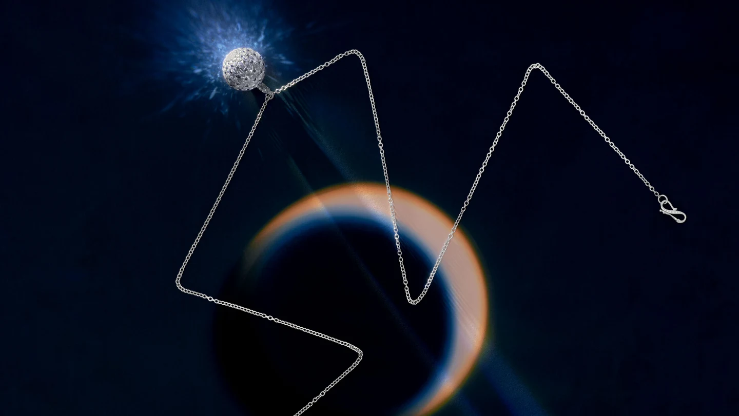 A diamond necklace against a dark blue reflective background