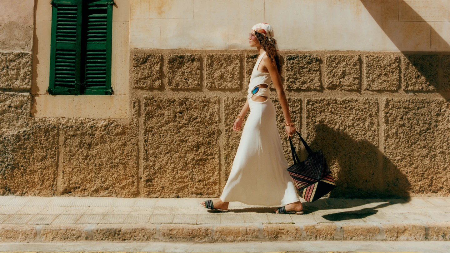 A flowing white outfit against a warm stone wall