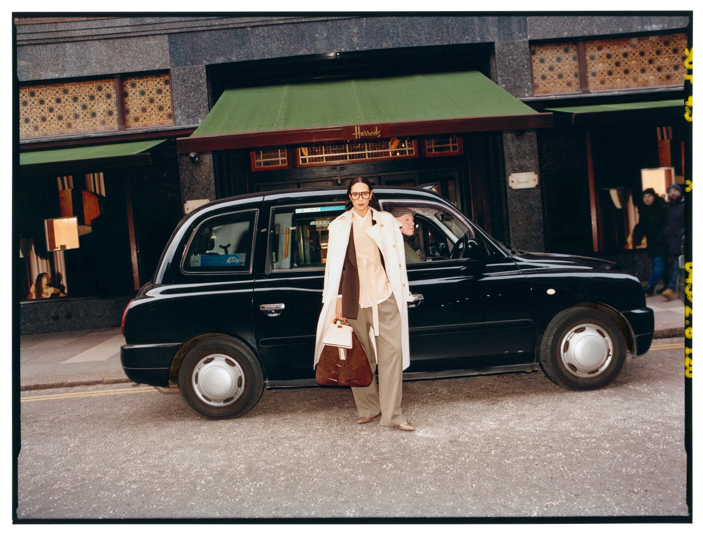 A spring outfit beside a black London taxi